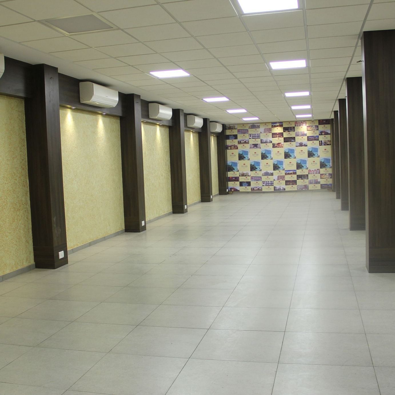 Long banquet hall with ceiling lights and wooden columns
