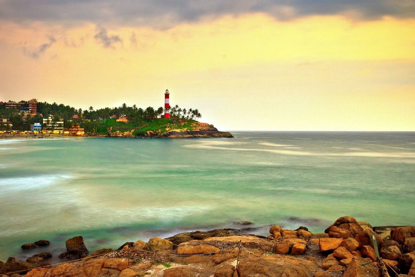 An overview of a beach with a light house in the background in Kovalam