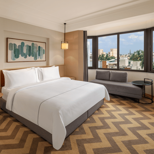 Suite room featuring a cozy bed and elegant bedside lamps at The Residency Chennai