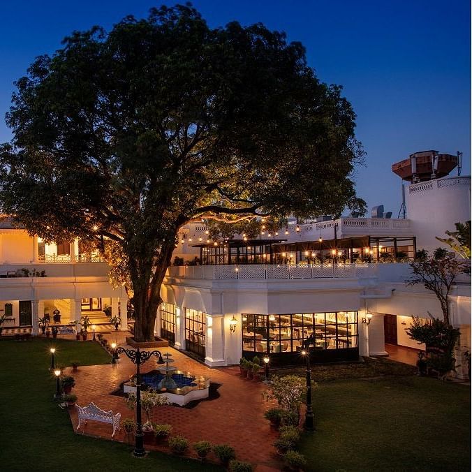 Image showing a large tree in front of a bespoke residence with a fountain, carefully put together on a lawn.