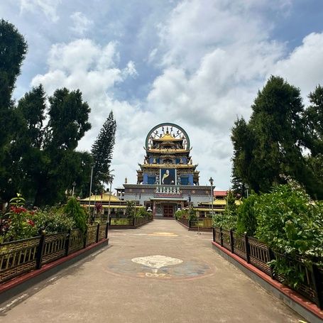 Namdroling Monastery with lush gardens and blue sky.