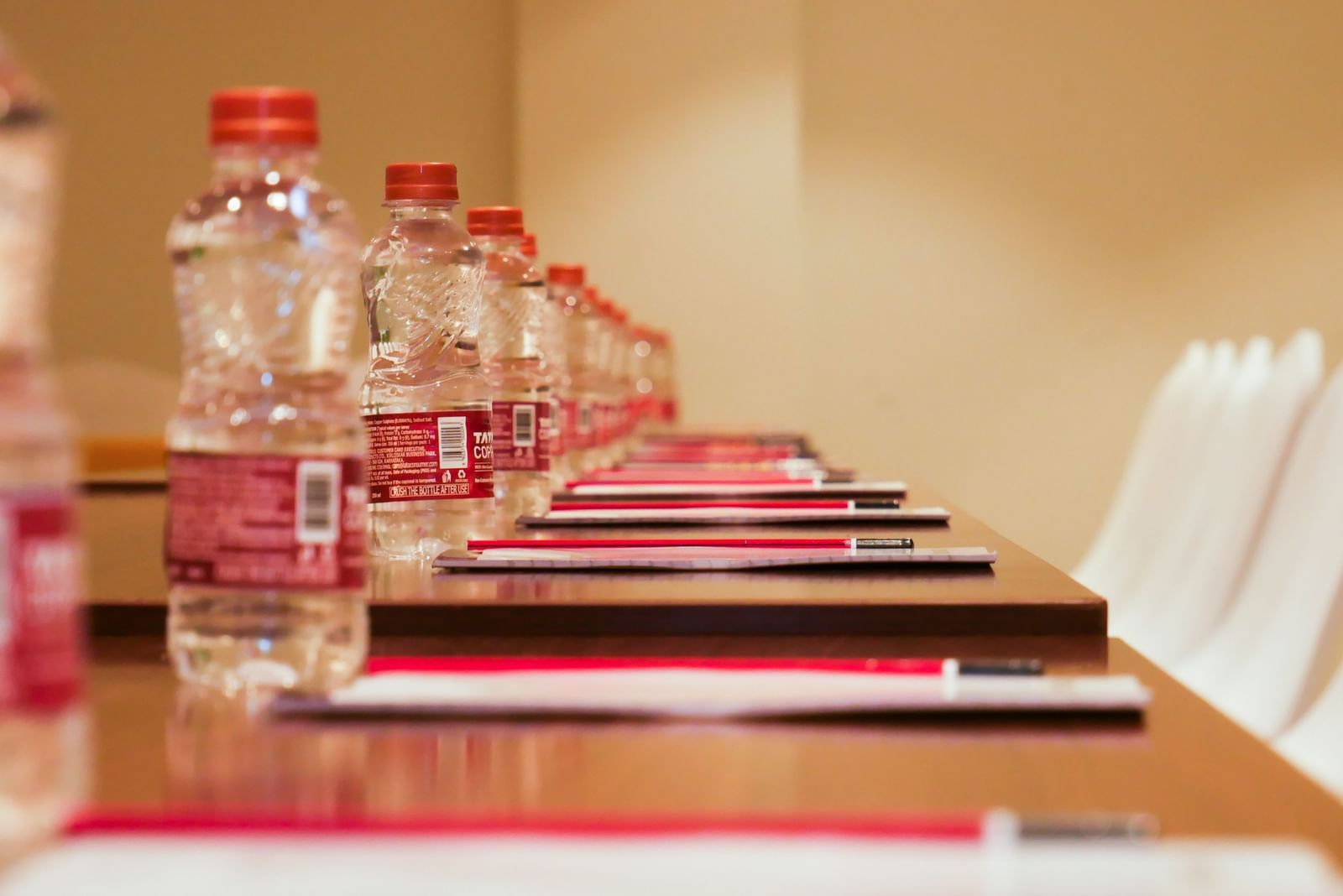 A conference table neatly set with water bottles and stationery, prepared for a productive meeting at Shilton Dee Cee.
