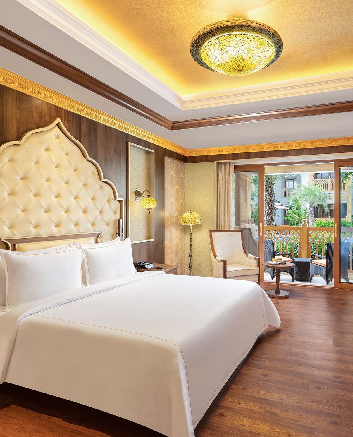 A hotel room in Mahabalipuram with rich wooden flooring, a large bed, and comfortable seating arrangement – Kaldan Samudra, one of the finest Mahabalipuram beach resorts