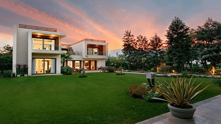 Facade view of Woodpecker Villa with a manicured garden in front of it - Karma Lakelands.