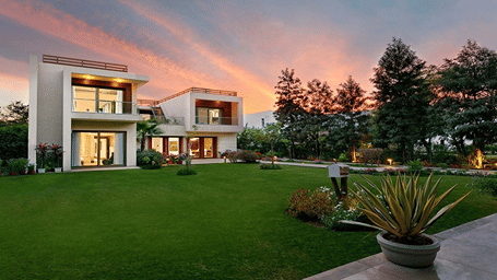 Facade view of Woodpecker Villa with a manicured garden in front of it - Karma Lakelands.
