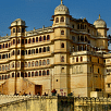 The City Palace in Udaipur, Rajasthan, a large,  building with domes, under a bright sky. 