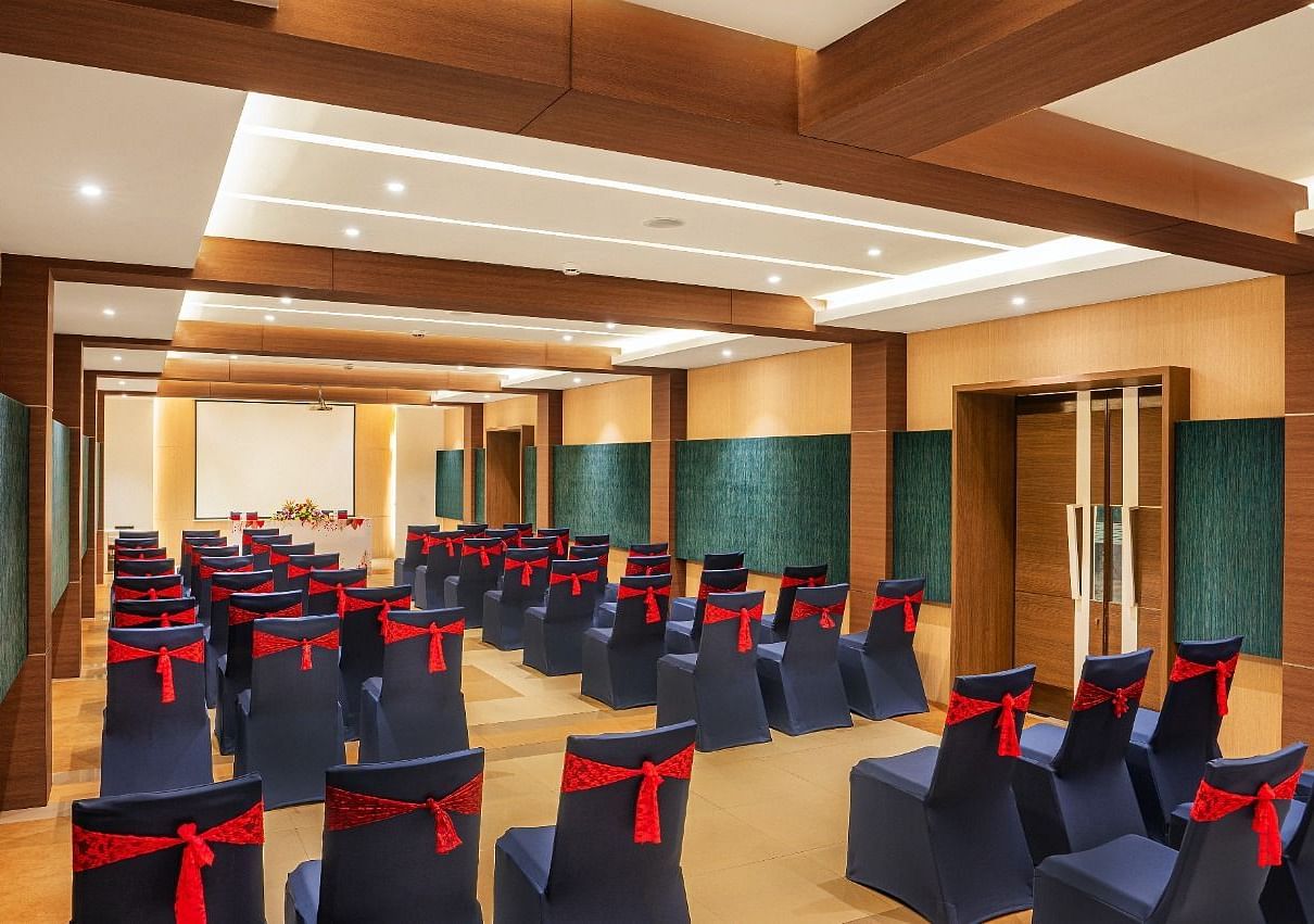 An image of huge wooden ceiling  hall with well arranged chairs at Grand Kakinada by GRT Hotels