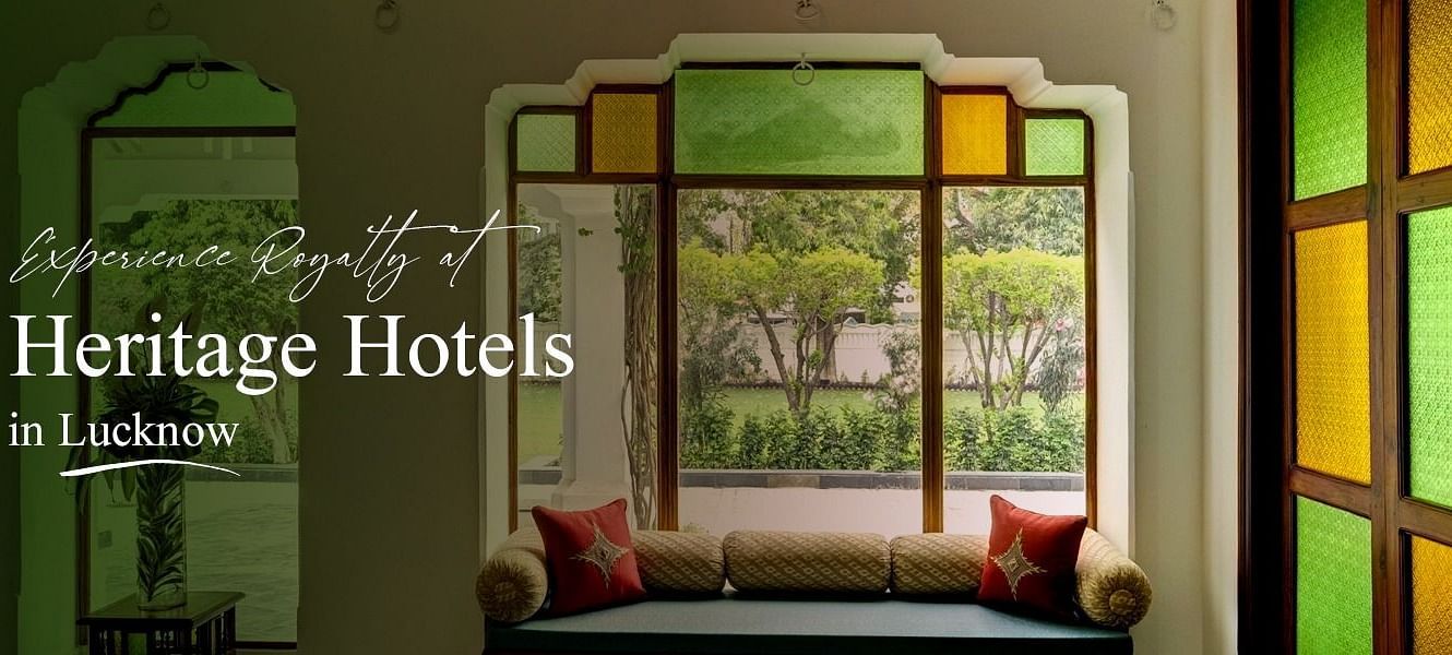 Experience Royalty at Heritage Hotels in Lucknow featuring an elegant indoor seating area adorned with traditional stained glass windows.