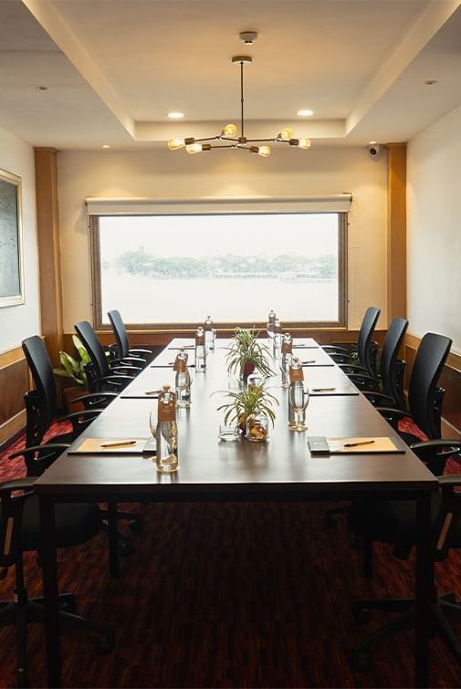 Boardroom at Polo Floatel Kolkata with a long central table, high-backed chairs, and a window with river view.