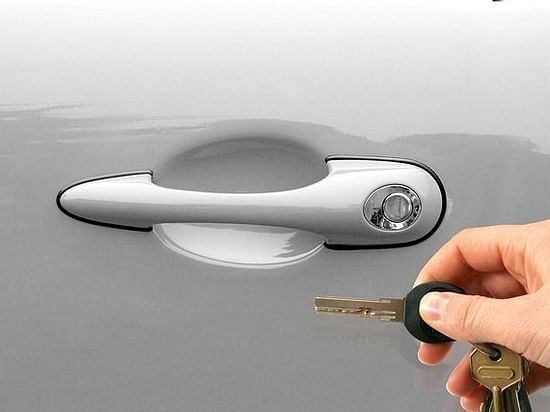 hand of a person trying to unlock the car with keys