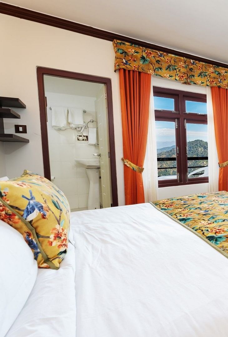 Image of a room with bed and a television in front at Summit Sherpa Mountain Hotel & Spa, Kalimpong