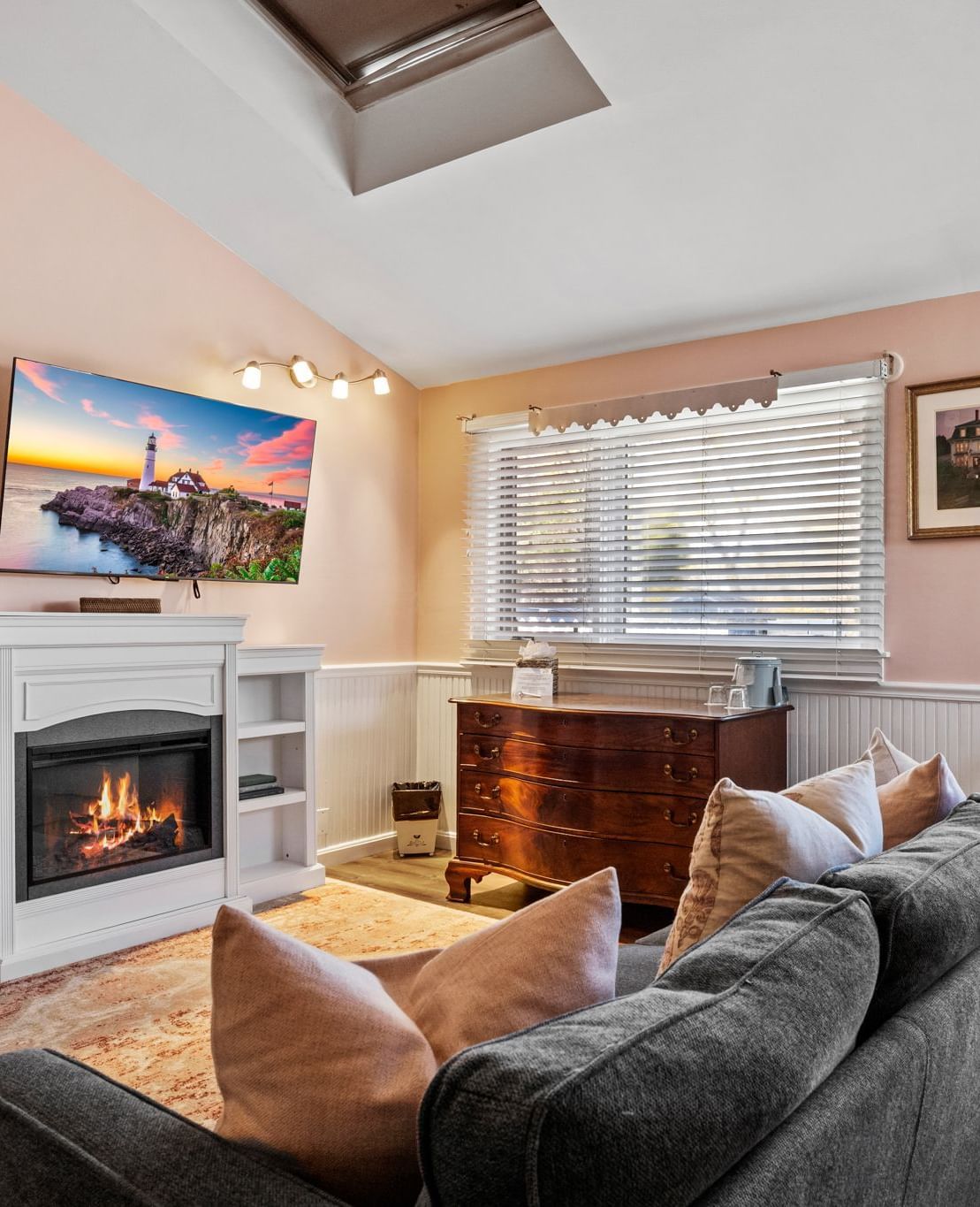 Living room with fireplace, flat screen TV, and large window at Hartstone Inn