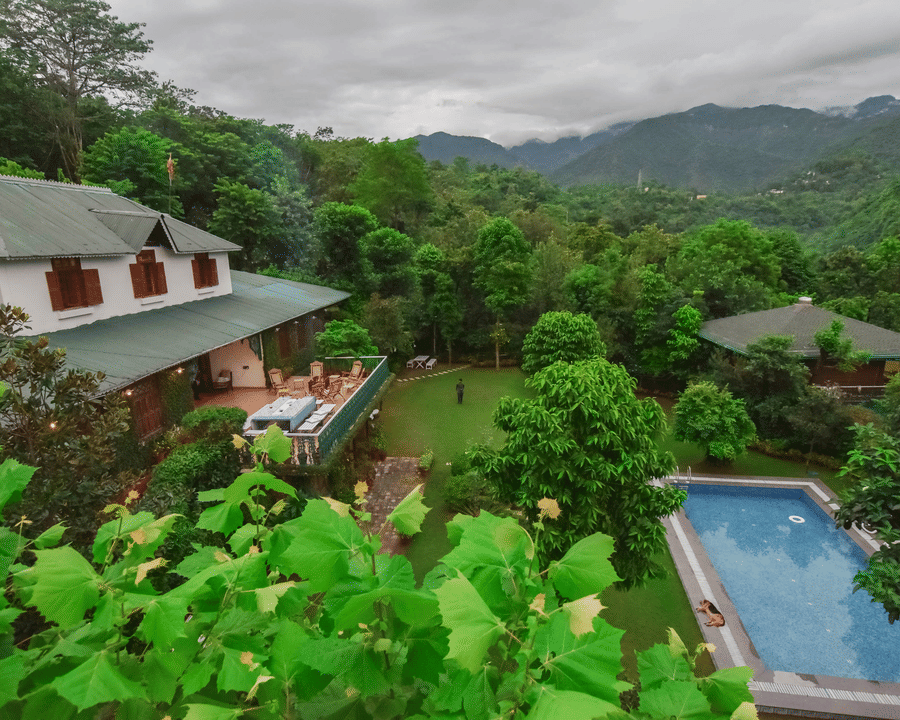 An aerial view of the lush green landscape with a resort nestled amongst the hills.