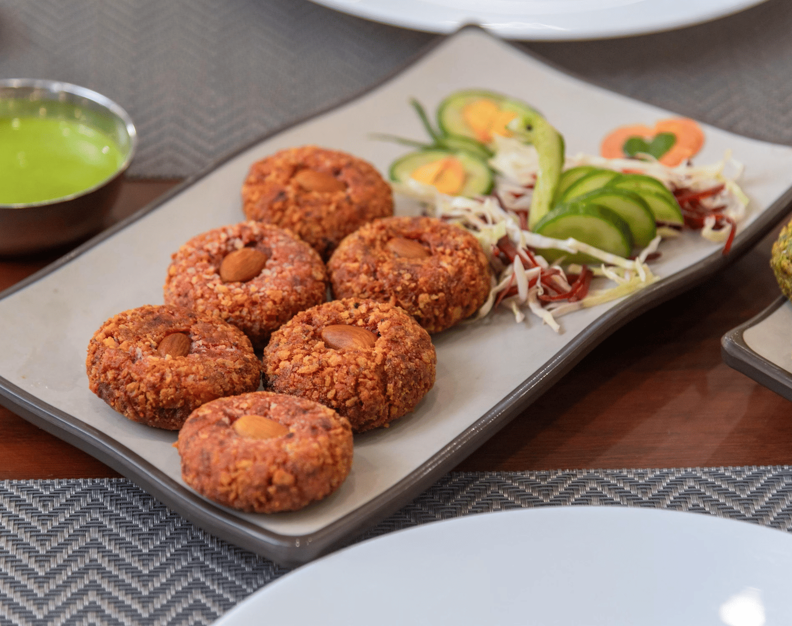 A plate with kebabs and a garnish of cut vegetables at Perfectstayz Premium Shanti Heritage, Haridwar