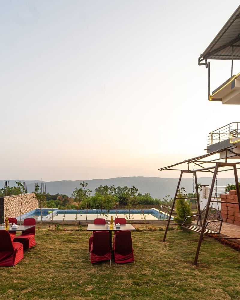 Outdoor lawn area next to a swimming pool featuring seating arrangements and a swing.