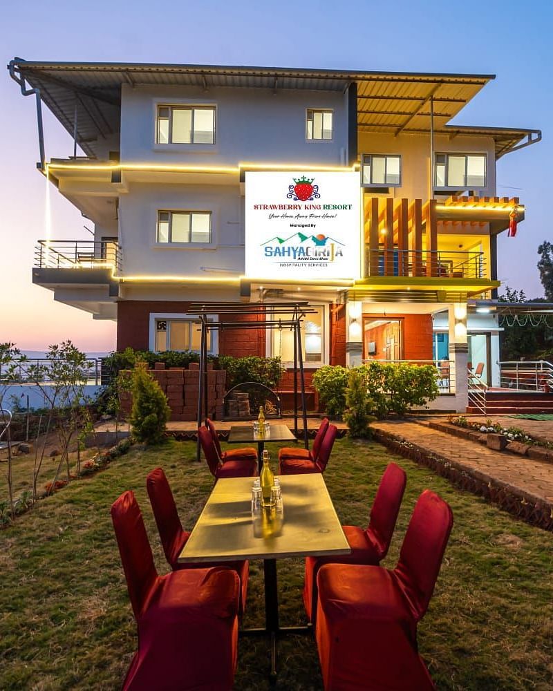 An exterior view of Strawberry King Resort, Mahabaleshwar with outdoor seating.
