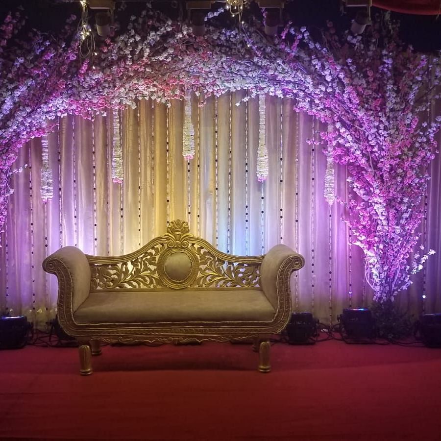 Image of a stage with a sofa and a backdrop of plants and lights at The Oriental Residency