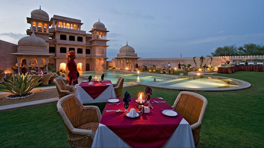 Poolside view of the property with a dining setup for couples  - Hotel Castle Mandawa, Jhunjunu