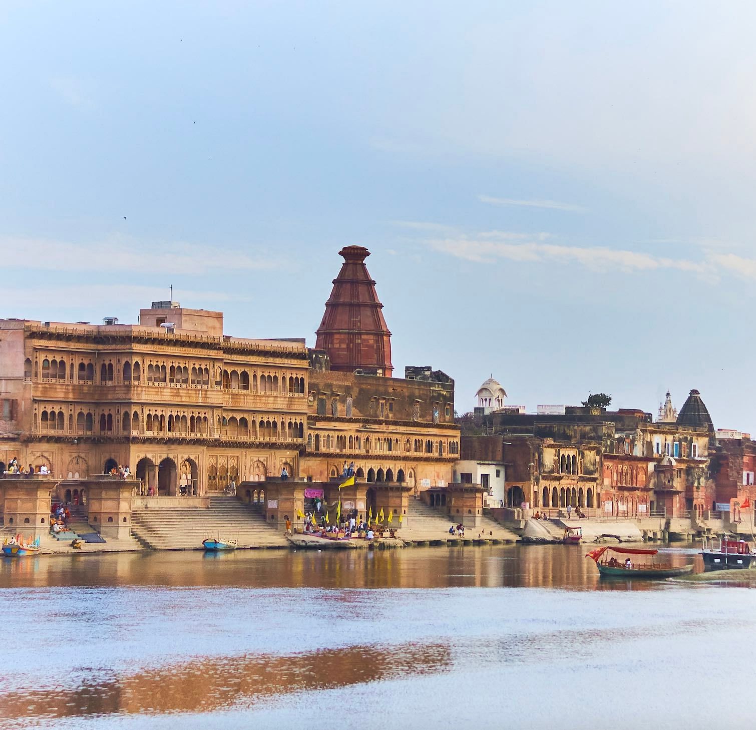 A image of religious structures near a river where devotees gather and worship