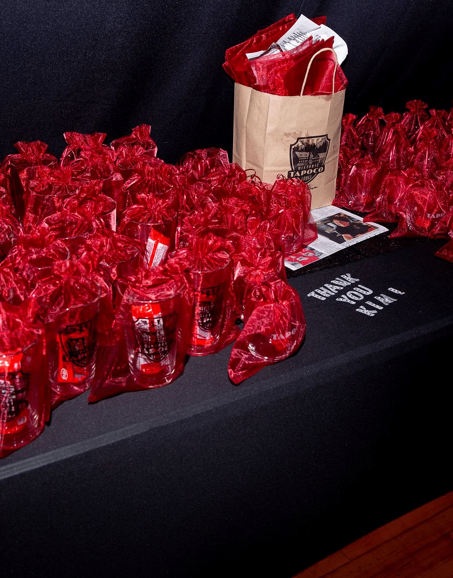 a table at the Tin Can Theater full of presents packed in small red colored packages for the attendees - Historic Tapoco Lodge