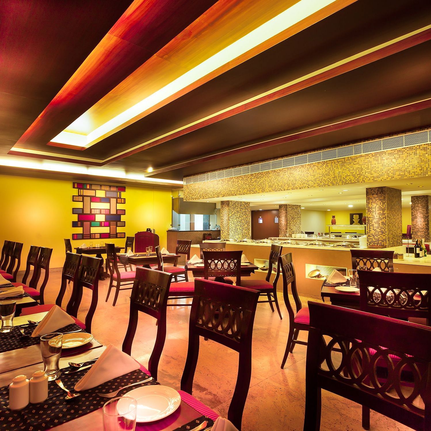 An image of a dining space with tables and chairs at Regency Madurai by GRT Hotels