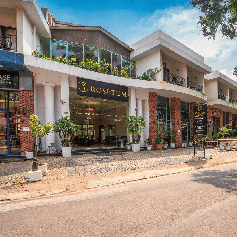 Street-facing exterior of Rosetum Hotels Anjuna with elegant entrance, balcony greenery, and adjacent Kérastase salon