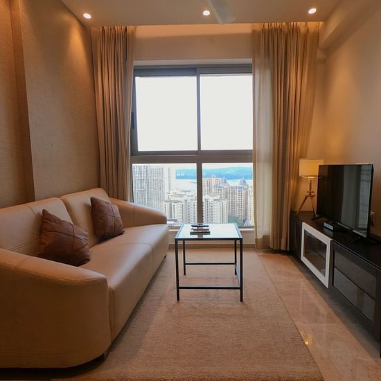 View of illuminated living area with sofa coffee table and TV set - Maxxvalue Apartment, Hiranandani, Powai