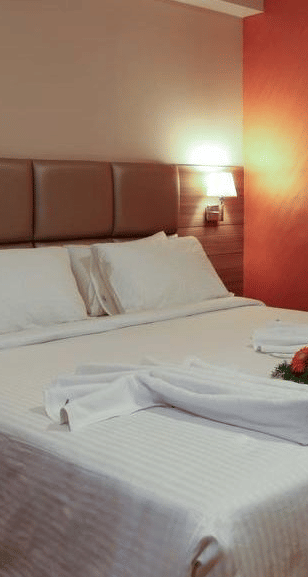 Close up view of room with flower arranged on the bed wit a side table at Fressotel Seetharam, Coimbatore