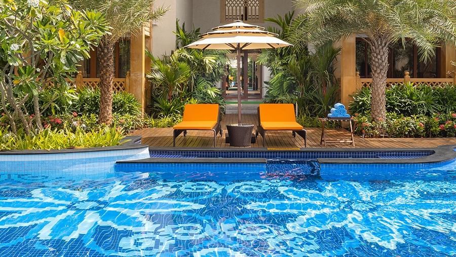 An image of our palace pool with sun loungers and palm trees on the deck - Kaldan Samudhra Palace