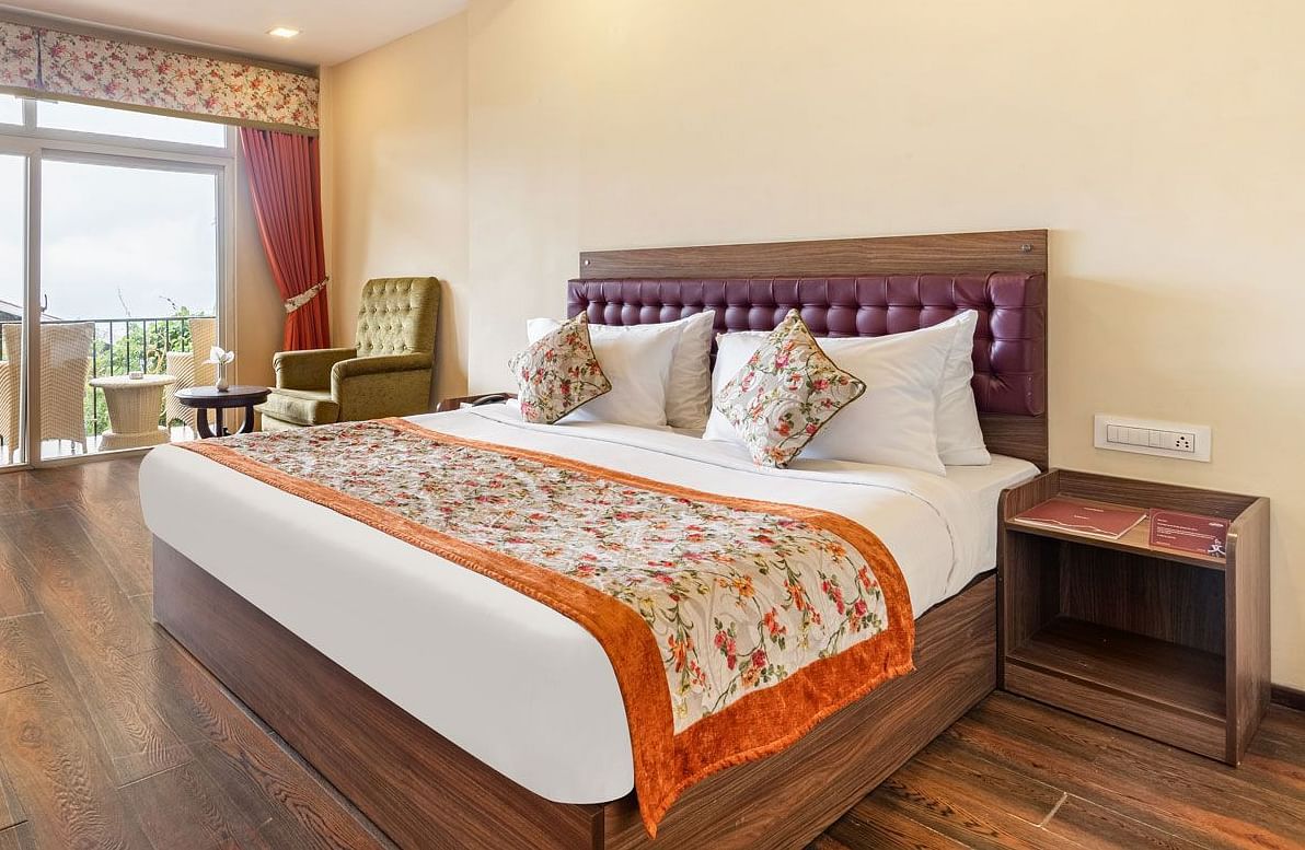 Deluxe room at Summit Barsana Resort & Spa, Kalimpong with a double bed and a balcony