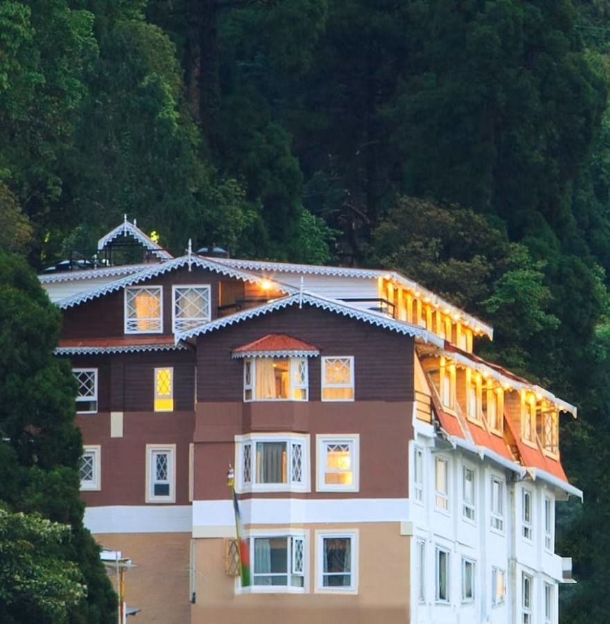 Front facade view of Summit Hermon Hotel & Spa, Darjeeling, surrounded by lush greenery