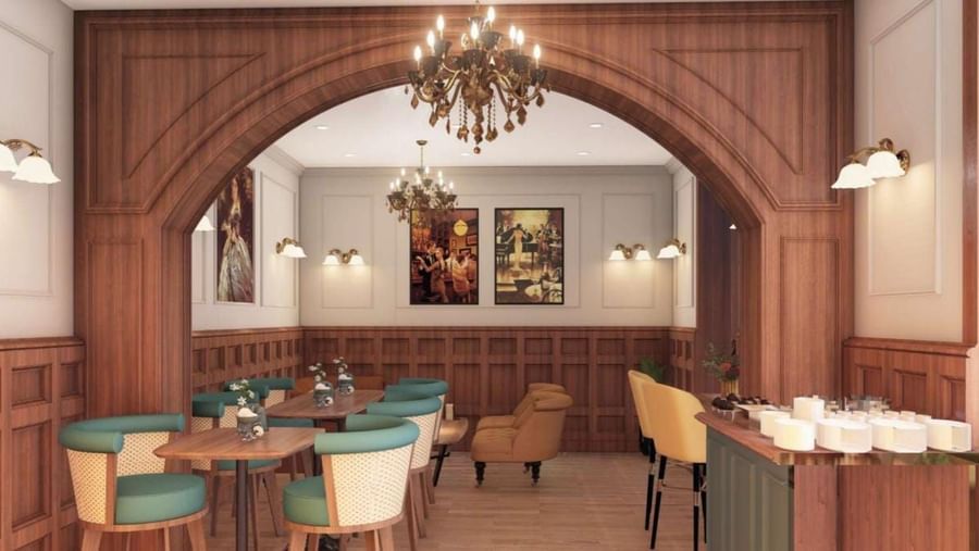 Elegant restaurant or hotel dining area featuring dark wood panelling, an arched doorway, and teal and mustard seating at BluSalzz Terrah Hills Resort, Dalhousie.
