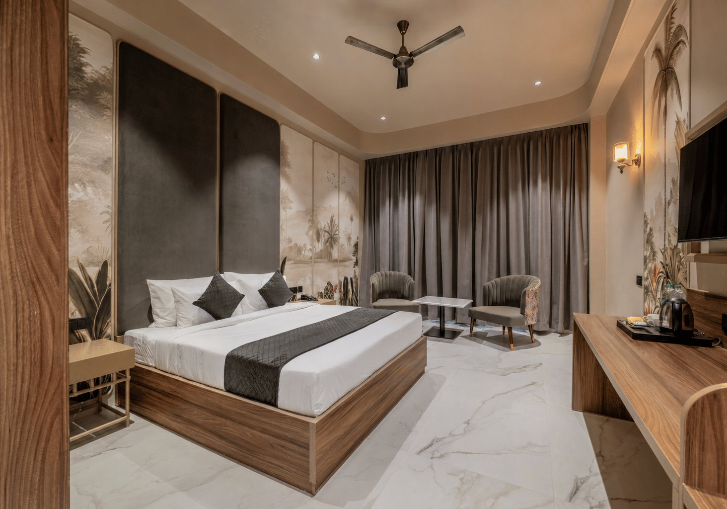 Bedroom with a double bed, wooden wardrobe, television, and upholstered seating.
