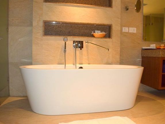 A bathtub with a cabinet and mirror in a bathroom setting.