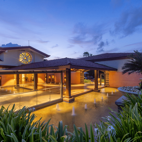 Facade view of the exterior of Kenilworth Resort and Spa, Goa, during twilight hour and the lights on.