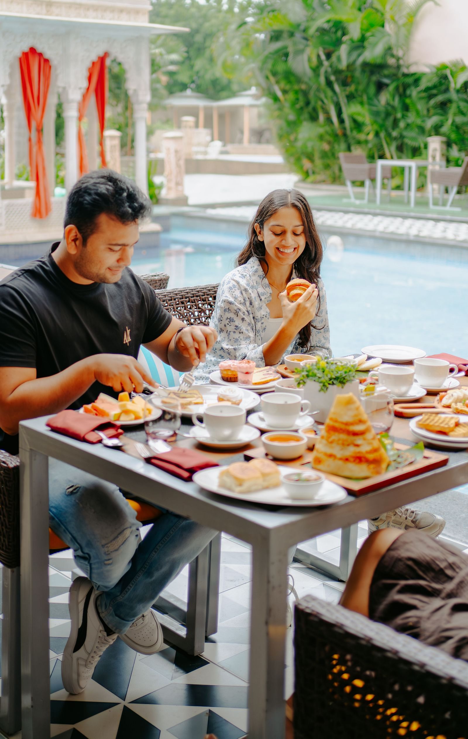 A couple enjoying their breakfast beside the pool area at Crescent Spa & Resort, Indore
