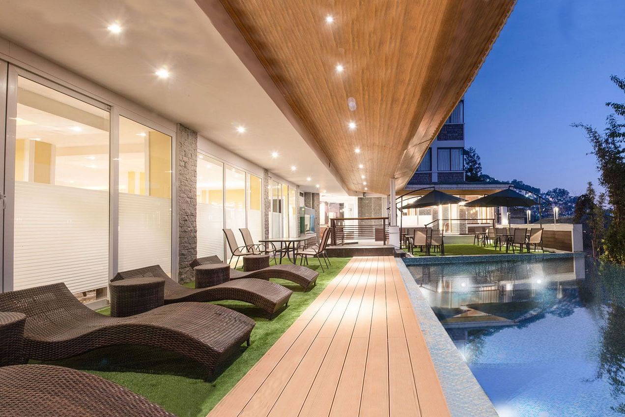 A night time view of a pool with sun loungers placed on its deck - Summit North Star, Gangtok