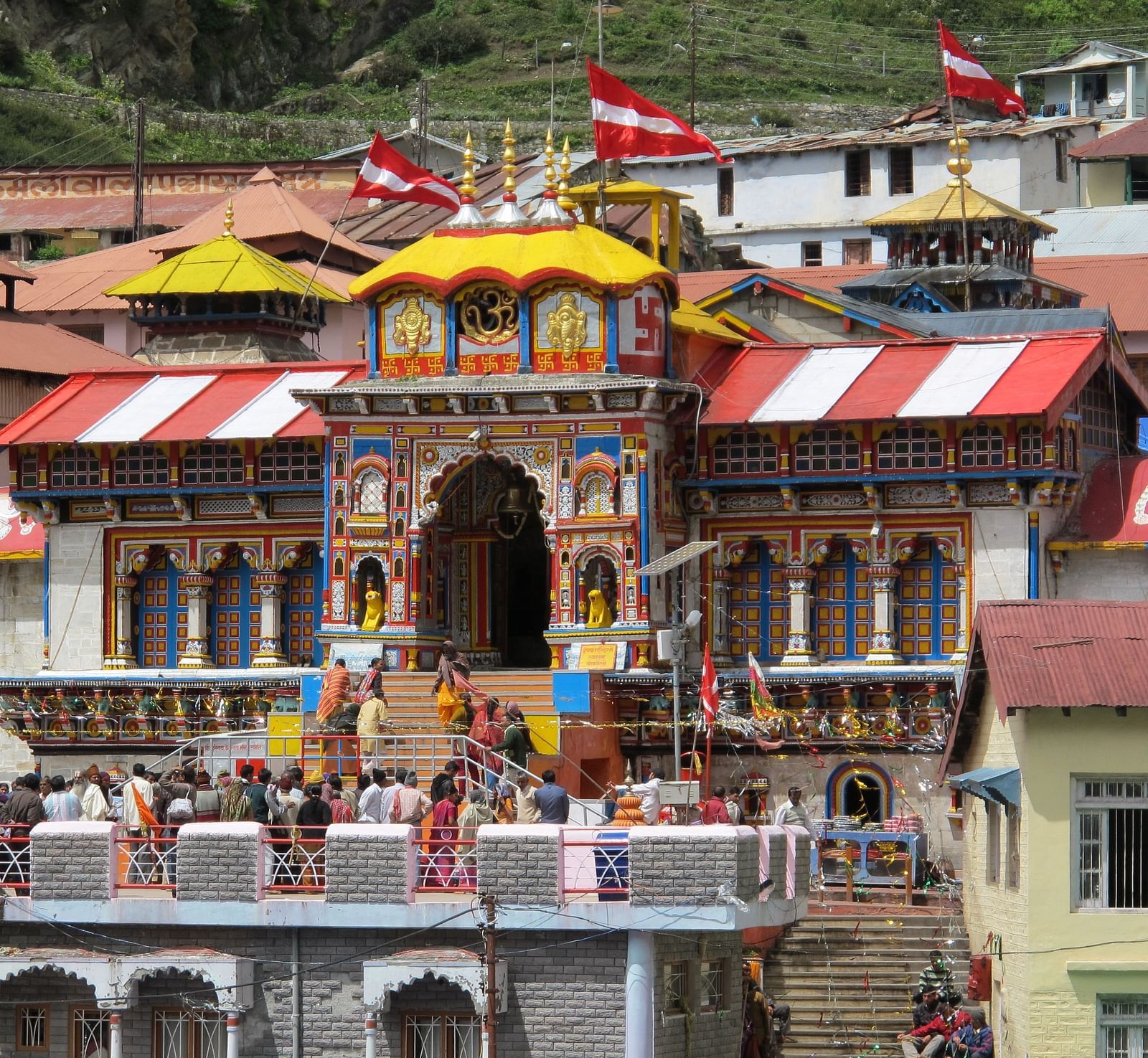 image of a temple with colourful exterior with red and white coloured flags hoisted