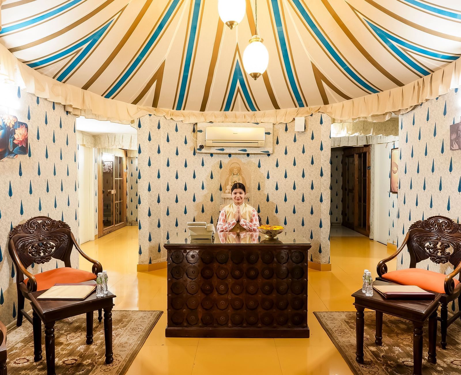An overview of the reception with a staff member greeting - Rajasthali Resort & Spa, Jaipur.