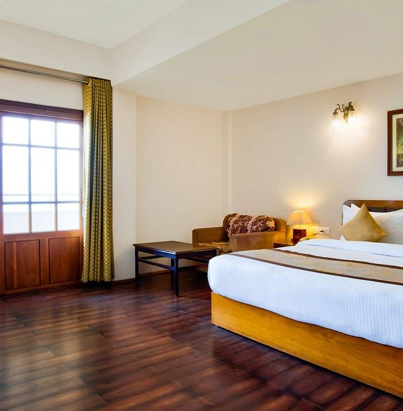 A view of a king size bed of a room at Summit Ttakshang Residency Hotel and Spa