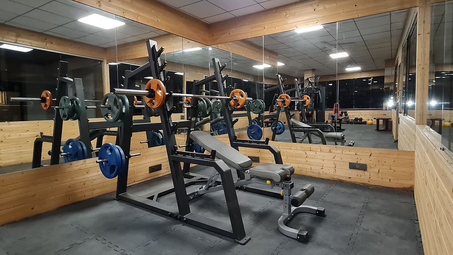 Modern gym equipment at Shaheen Bagh, set in a sleek mirrored workout space.