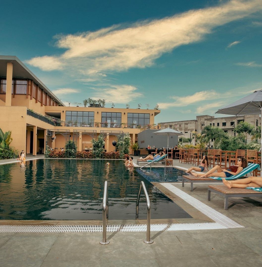 Outdoor swimming pool at at Singalila Club with lounging chairs placed along the periphery