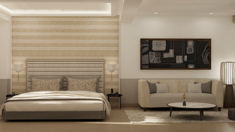 A room containing a king size bed, a sofa, a coffee table, and wall decorations at Shilton Suites, Bengaluru.