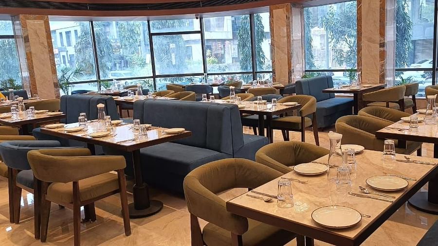 Restaurant with cutlery neatly placed on the table at Hotel Mumbai House, Vashi.