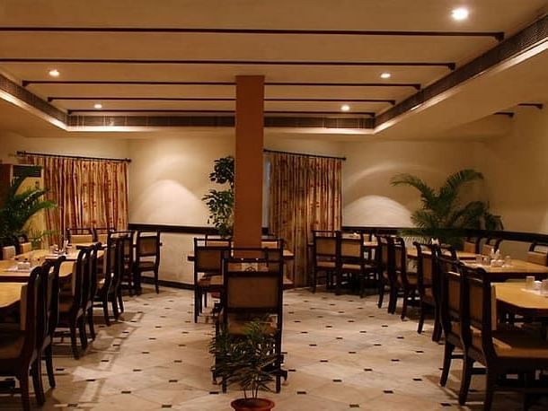 Side view of Akshara Restaurant with multiple chairs and modern interior - Jayaram Hotel, Pondicherry