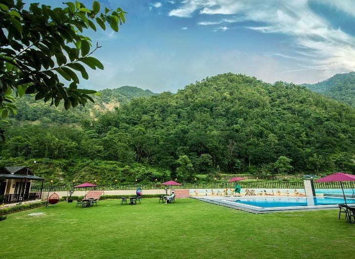 View of the swimming pool during the day at DLS MJ River Resort, Rishikesh.