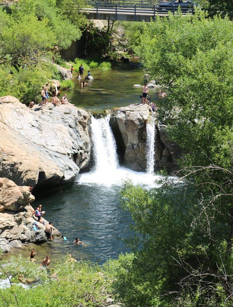 Aerial view of Rainbow Pools, featuring stunning waterfalls surrounded by lush greenery and natural rock formations