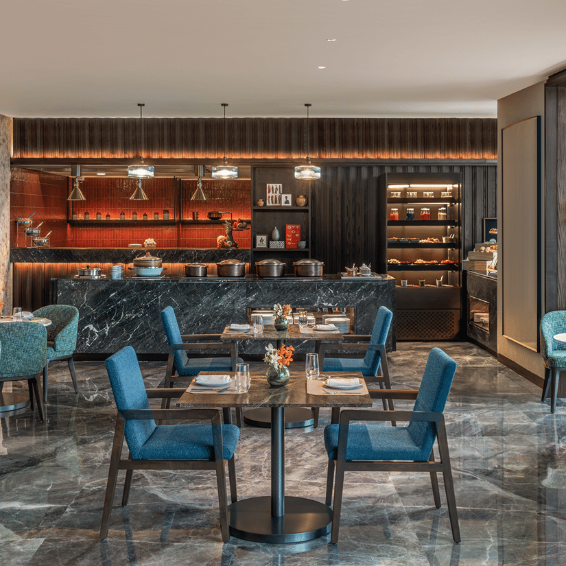 Executive Lounge with a bar counter, teal chairs and marble flooring at The Residency Signature Madurai.