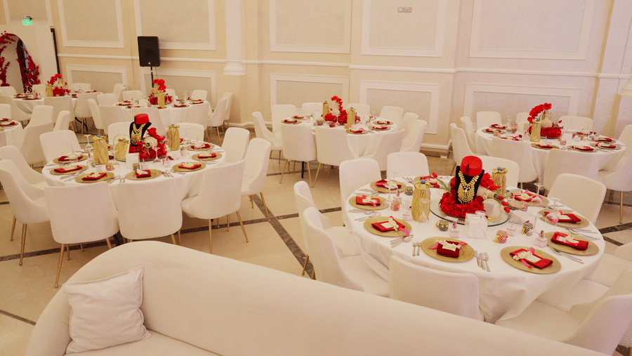 A close-up shot of a decorated table at La Maison, Doha, with a focus on floral arrangements and place settings in a banquet hall.