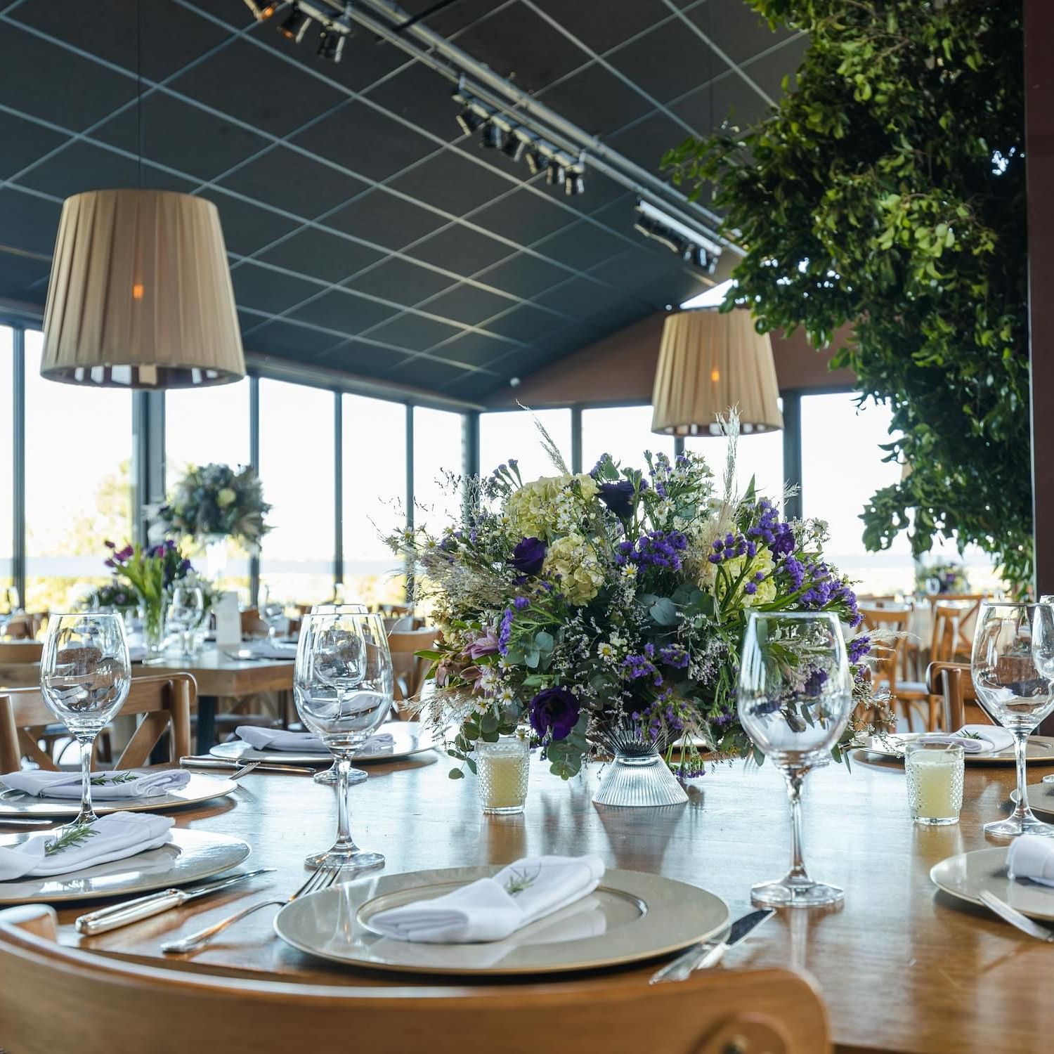 Banquet hall with cutley on the table and lights hamging from the ceiling